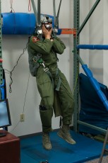 An aircrew member protects his face and limbs from a hard landing in the forest during a Virtual Reality Parachute Simulation