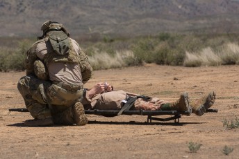 A Marine from 1st Force Recon Company preps one of the injured for transport