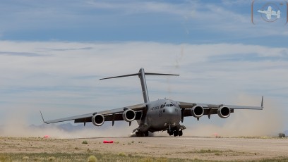Air Mobility Command C-17A of the 436th AW/512 AW, Dover, DE kicks up the dust as it lands at Keno Airfield on the NTTR during Joint Forcible Entry Exercise (June 2016). Residue of rocket flares launched from ground  during approach are visible in the background.
