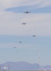 Ground launched rocket streaks in front of C-17A's incoming for airdrop on Keno field in the NTTR during JFEX (June 2016).