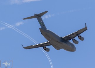 Air Mobility Command C-17A of the 62nd AW/446th AW McChord AFB, WA flies over Keno Airfield on the NTTR during Joint Forcible Entry Exercise (June 2016).  Condensation off the wingtips of an F-15C of the 433 WPS overhead indicate the air to air efforts to sanitize the area of Red Air (adversary) threats.
