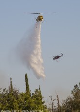 Bell 205-A1 makes water drop on the Azusa Fire on the hills North of Los Angeles June 20, 2016, as Sikorsky CH-54B is on the way back down for another tank of water.