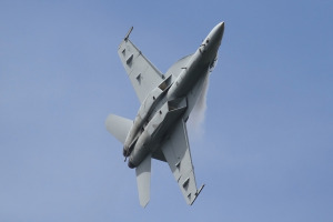An F/A-18 Super Hornet shreds vapor high above NAS Oceana