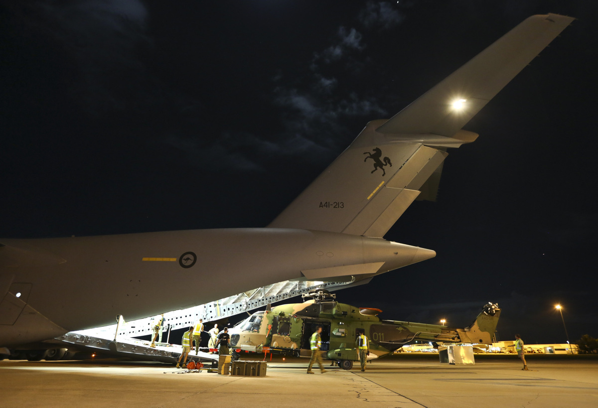 Air Force and Army working together to load a Multi Role Helicopter (MRH 90) onto a C-17 Globemaster as part of Operation Fiji Assist. *** Local Caption *** As part of Operation FIJI ASSIST, the Australian Defence Force is deploying four Australian Army Multi Role Helicopter-90 (MRH-90) aircraft via Royal Australian Air Force C-17A Globemaster from RAAF Base Townsville to Suva, Fiji. The MRH-90s from the Townsville-based 5th Aviation Regiment (5 AVN) will support the Whole of Government Humanitarian Assistance and Disaster Relief (HADR) operations in the wake of Tropical Cyclone (TC) Winston which struck the islands of Fiji on 20 February 2016. The MRH-90, which will support the Fijian Government with damage assessment and aid distribution to outlying Fijian islands, is one of the most advanced transport helicopters of today and is designed for operations in poor weather.