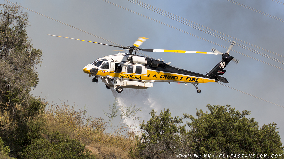 Sikorsky S-70A Firehawk making water drop on the Azusa Fire in close proximity to power transmission lines. On the hills North of Los Angeles June 20, 2016